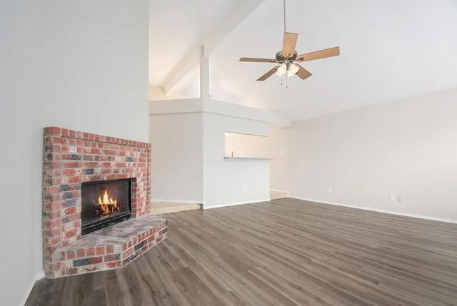 a view of empty room with wooden floor and fireplace