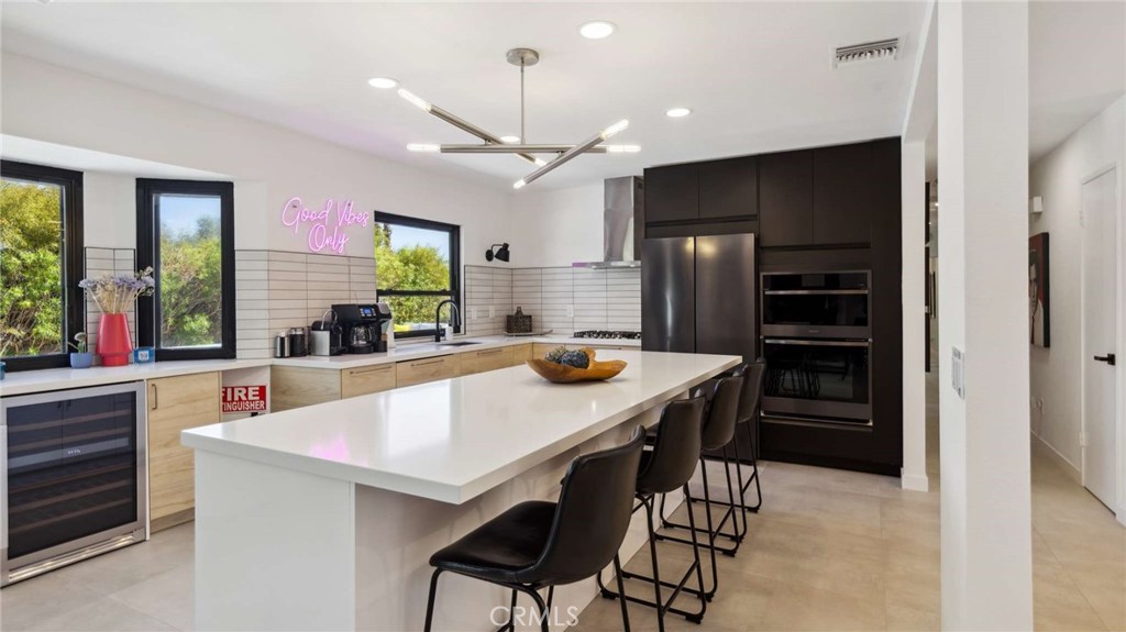 2004 East Nicola Road Palm Springs, CA 92262 - Photo 16 of 40 a kitchen with stainless steel appliances kitchen island granite countertop a refrigerator a sink a stove and chairs