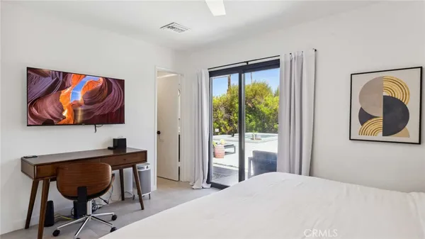 a bedroom with a bed and a painting on the wall