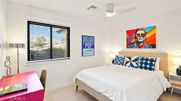 a bedroom with a bed and a painting on the wall