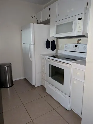 a kitchen with a stove top oven and refrigerator