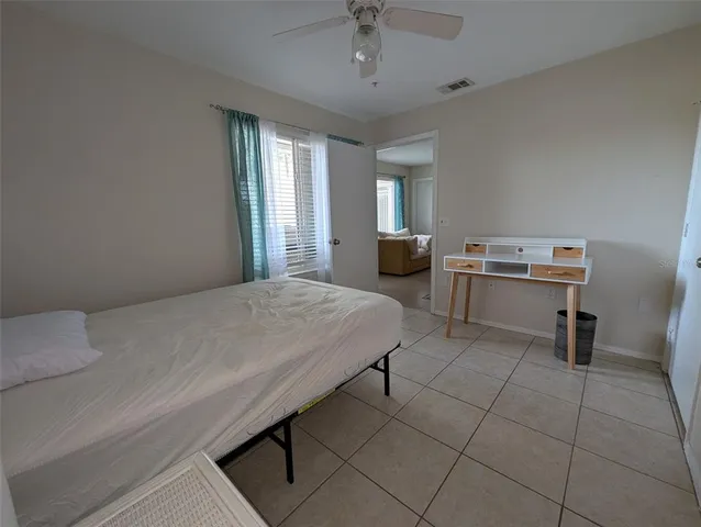 a spacious bedroom with a bed and a table chair