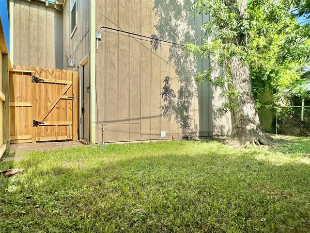 a tree in a yard with wooden fence