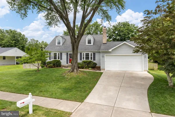 a front view of a house with a yard and trees
