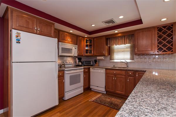 19 Carroll Road Woburn, MA 01801 - Photo 5 of 12 a kitchen with stainless steel appliances granite countertop a refrigerator a sink dishwasher a stove with wooden cabinets and floor