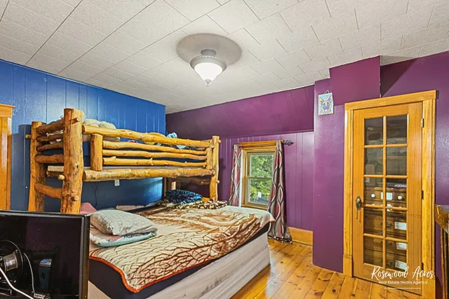 a bedroom with a bed and wooden floor