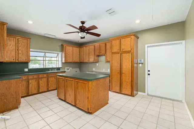 a kitchen with stainless steel appliances granite countertop a refrigerator a sink dishwasher and a stove with wooden cabinets