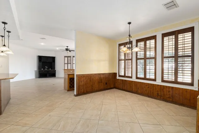 a view of an empty room with window and cabinet
