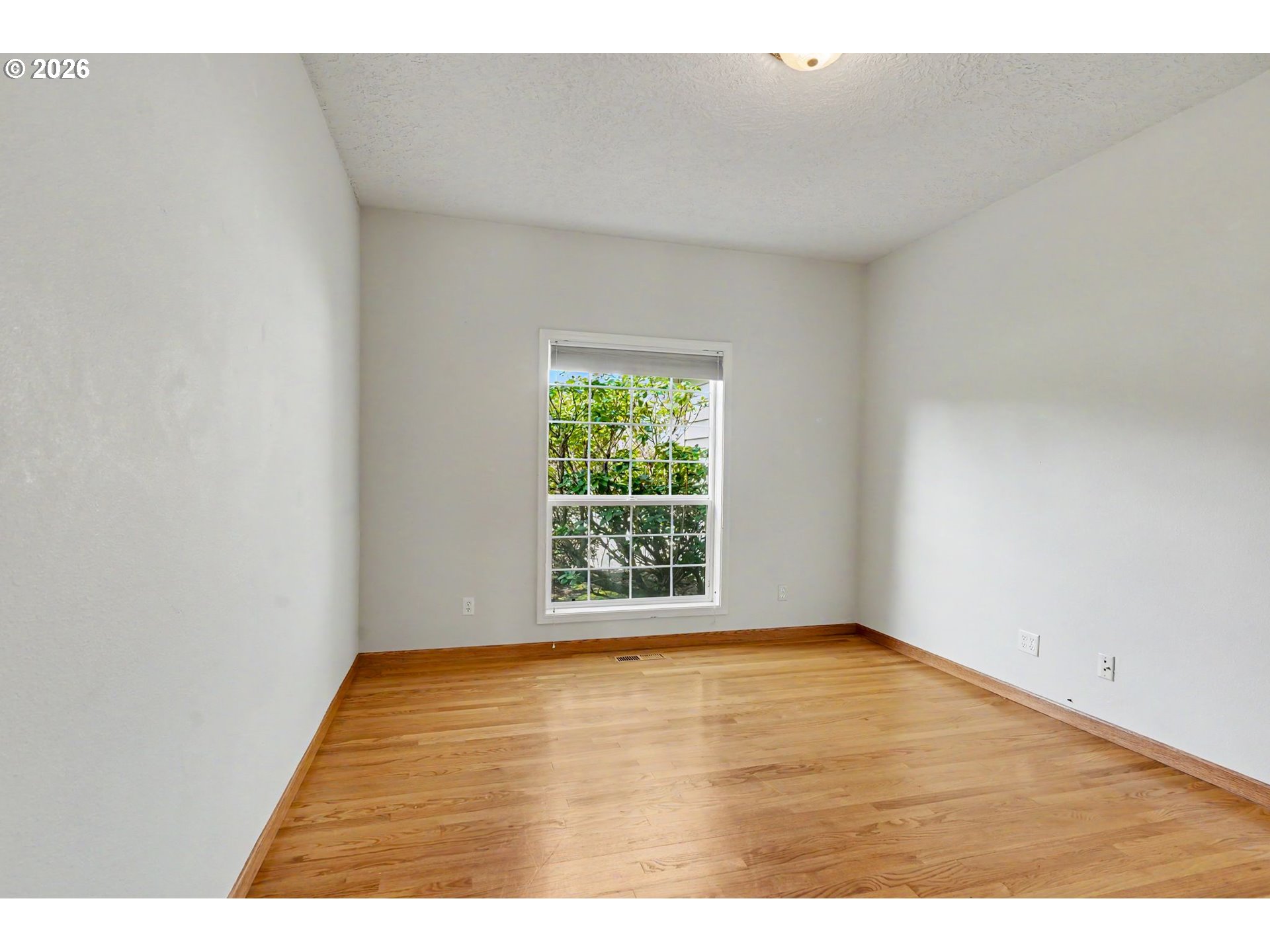 1470 Ranier Loop Northwest Salem, OR 97304 - Photo 26 of 48 a view of an empty room with wooden floor and a window
