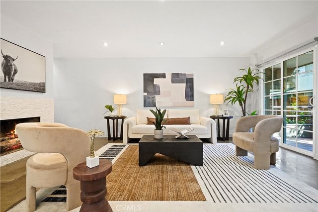 a living room with furniture wooden floor and a large window