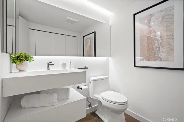 a bathroom with a sink mirror and toilet