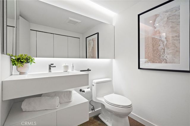 a bathroom with a sink mirror and toilet