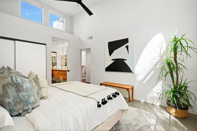 a bedroom with a bed and a potted plant