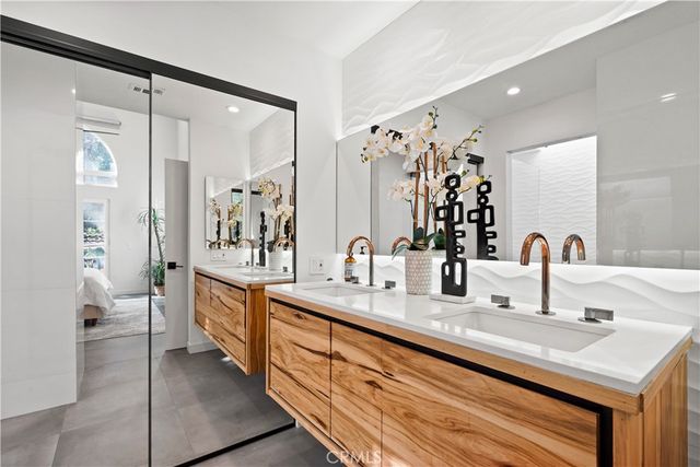 a bathroom with double vanity sinks a mirror and a shower