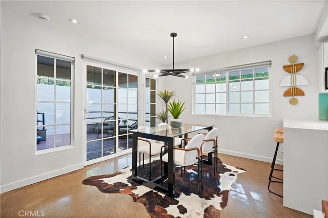 a dining room with furniture a chandelier and wooden floor