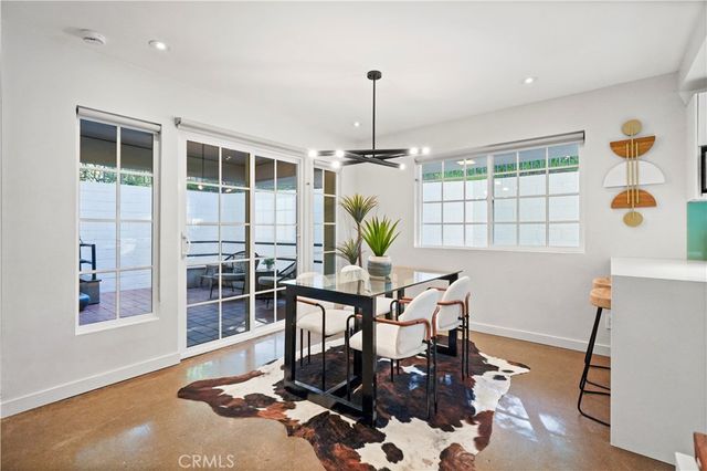 a dining room with furniture a chandelier and wooden floor