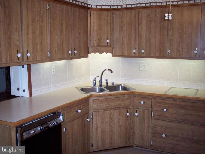 115 Ashton Road Ashton, MD 20861 - Photo 13 of 25 a kitchen with a sink cabinets and wooden floor