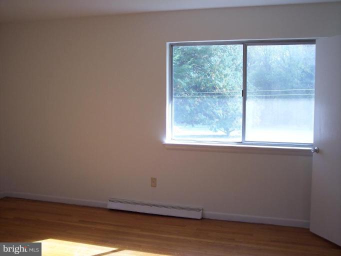 115 Ashton Road Ashton, MD 20861 - Photo 16 of 25 a view of an empty room with wooden floor and a window