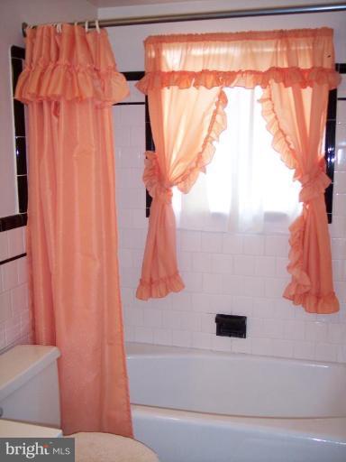 115 Ashton Road Ashton, MD 20861 - Photo 18 of 25 a bathroom with a shower curtain and a sink