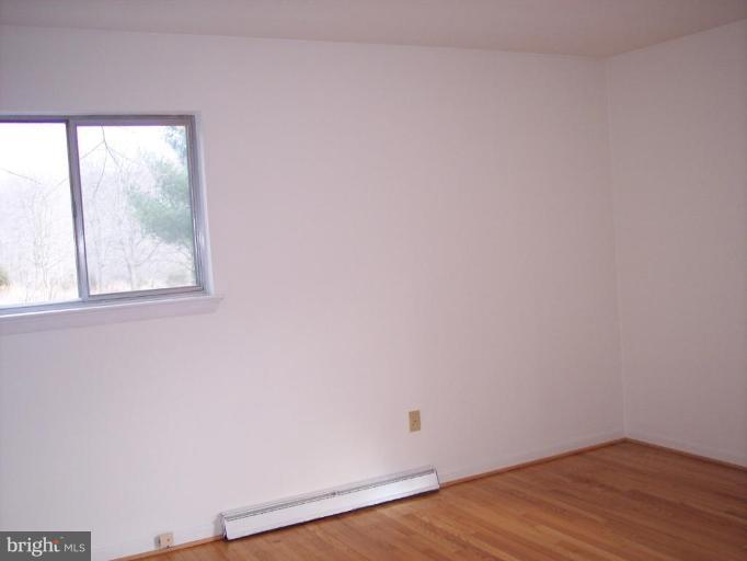115 Ashton Road Ashton, MD 20861 - Photo 21 of 25 an empty room with wooden floor and windows