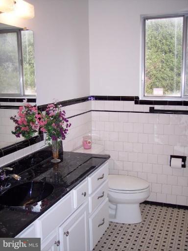 115 Ashton Road Ashton, MD 20861 - Photo 23 of 25 a bathroom with a granite countertop sink a toilet and a window