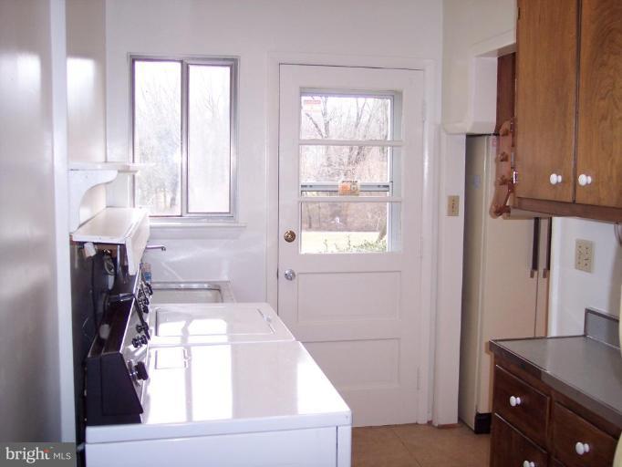 115 Ashton Road Ashton, MD 20861 - Photo 24 of 25 a kitchen with a window a refrigerator and a stove top oven