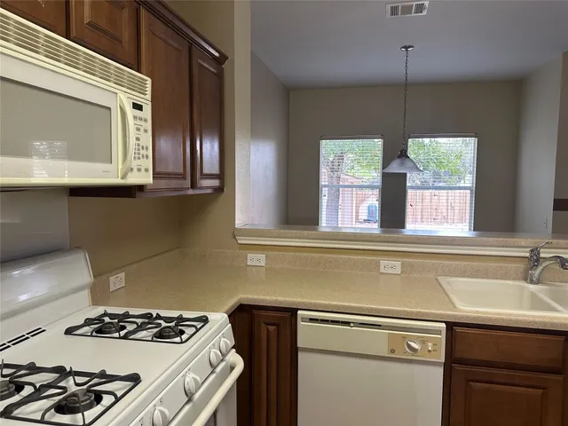 a kitchen with a stove a sink and a microwave