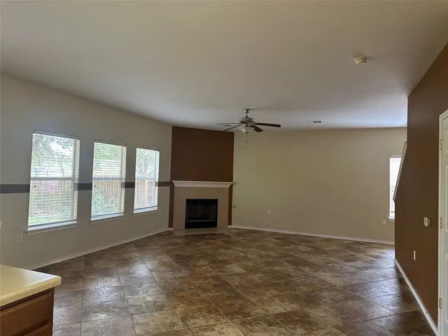 a view of an empty room with a fireplace and a window