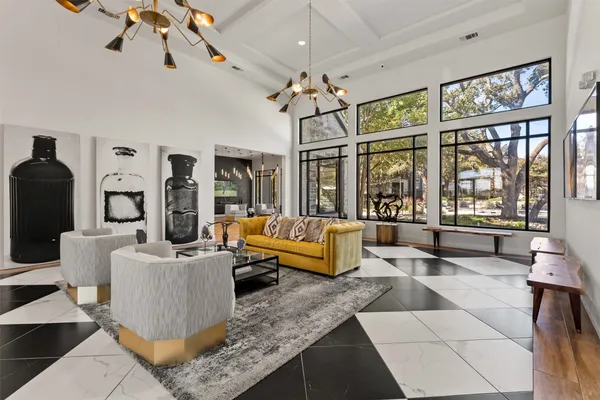 a living room with furniture a chandelier and a large window
