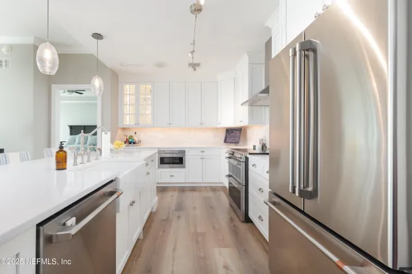 a kitchen with white cabinets and stainless steel appliances