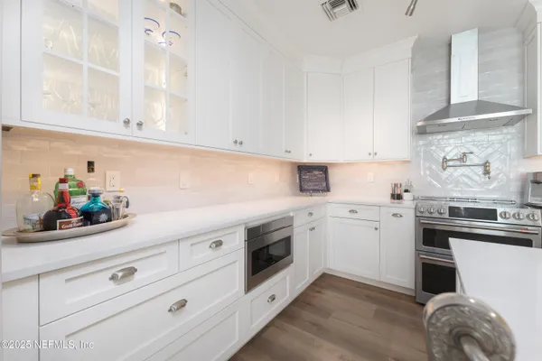 a kitchen with granite countertop white cabinets and white appliances