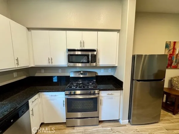 a kitchen with a refrigerator and a stove top oven