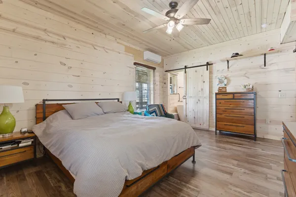 a bedroom with bed dresser and a chandelier