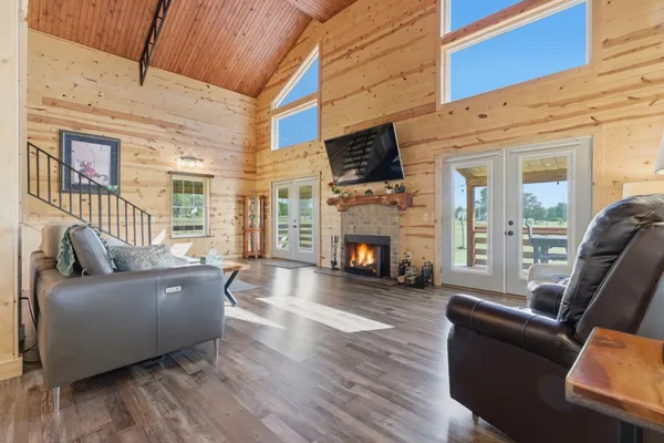 a living room with furniture a fireplace a flat screen tv and a large window