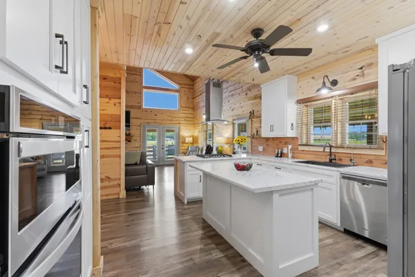 a kitchen with stainless steel appliances a sink a stove top oven a counter space and cabinets