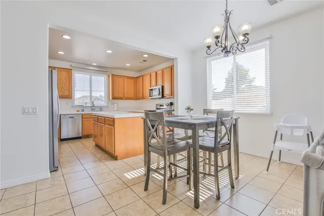 a kitchen with stainless steel appliances granite countertop a stove a sink a dining table and chairs