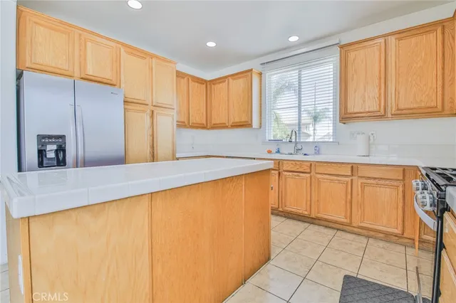 a kitchen with stainless steel appliances a sink a refrigerator and cabinets