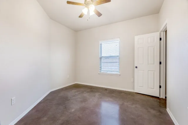 an empty room with a chandelier fan