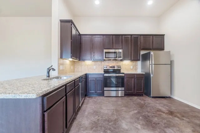 a kitchen with a sink refrigerator and a stove