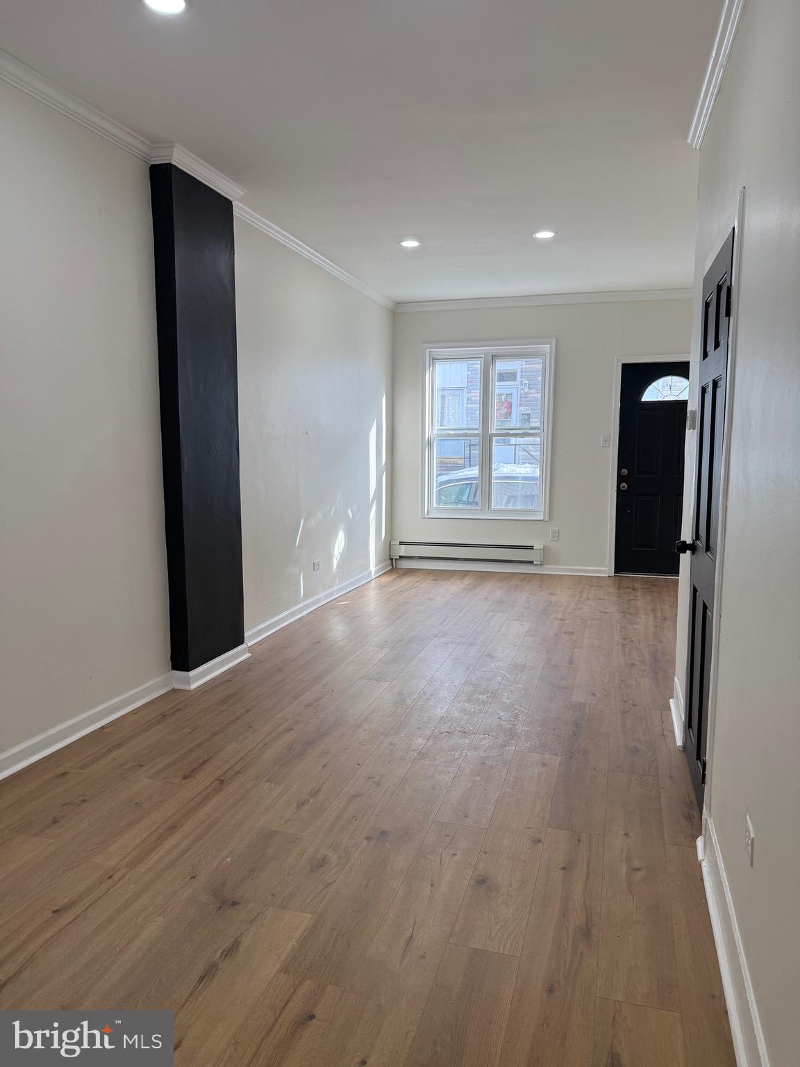 542 Moss Street Reading, PA 19604 - Photo 3 of 19 a view of an empty room with a window and wooden floor
