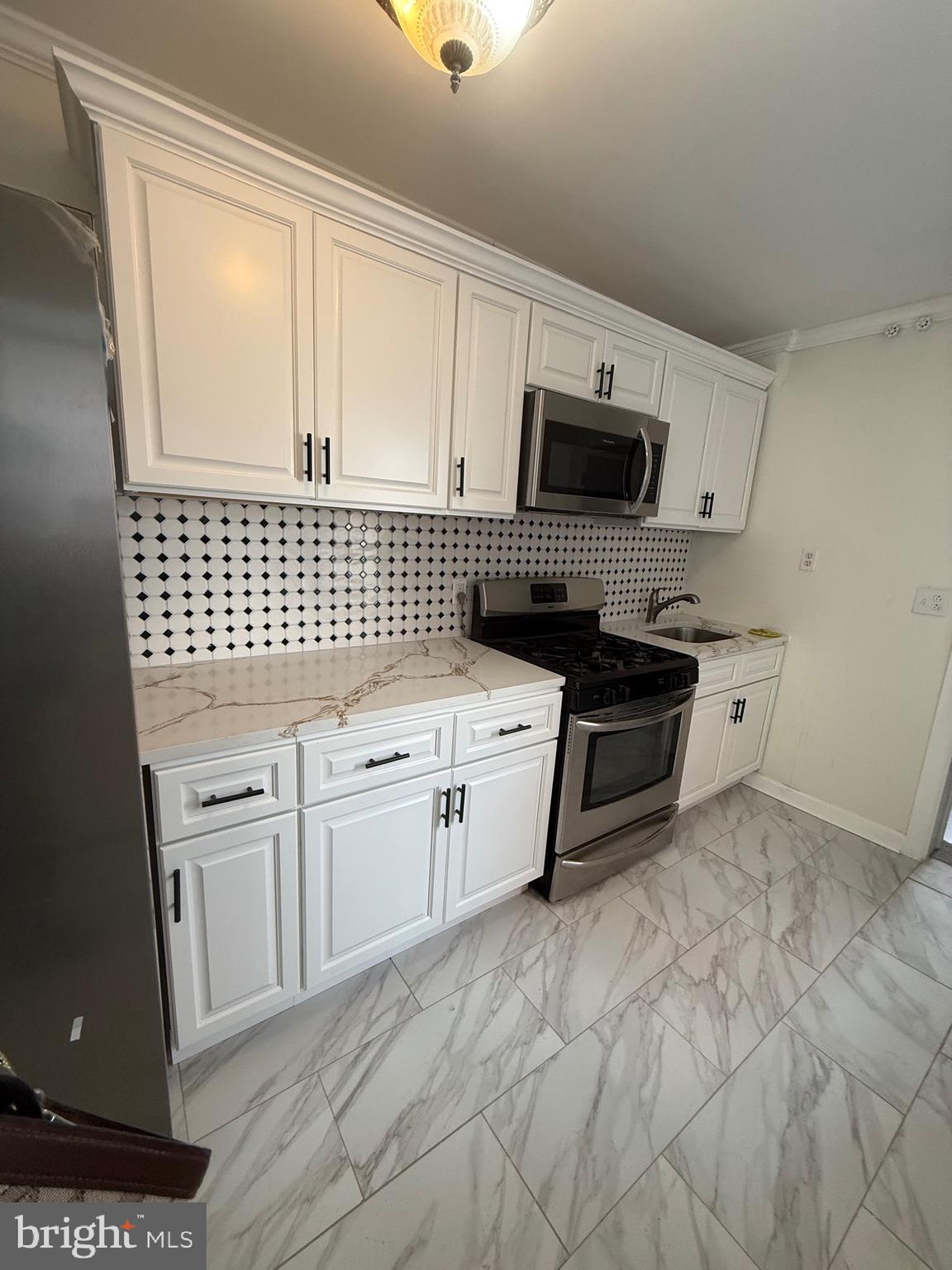 542 Moss Street Reading, PA 19604 - Photo 6 of 19 a kitchen with a stove a sink and a microwave
