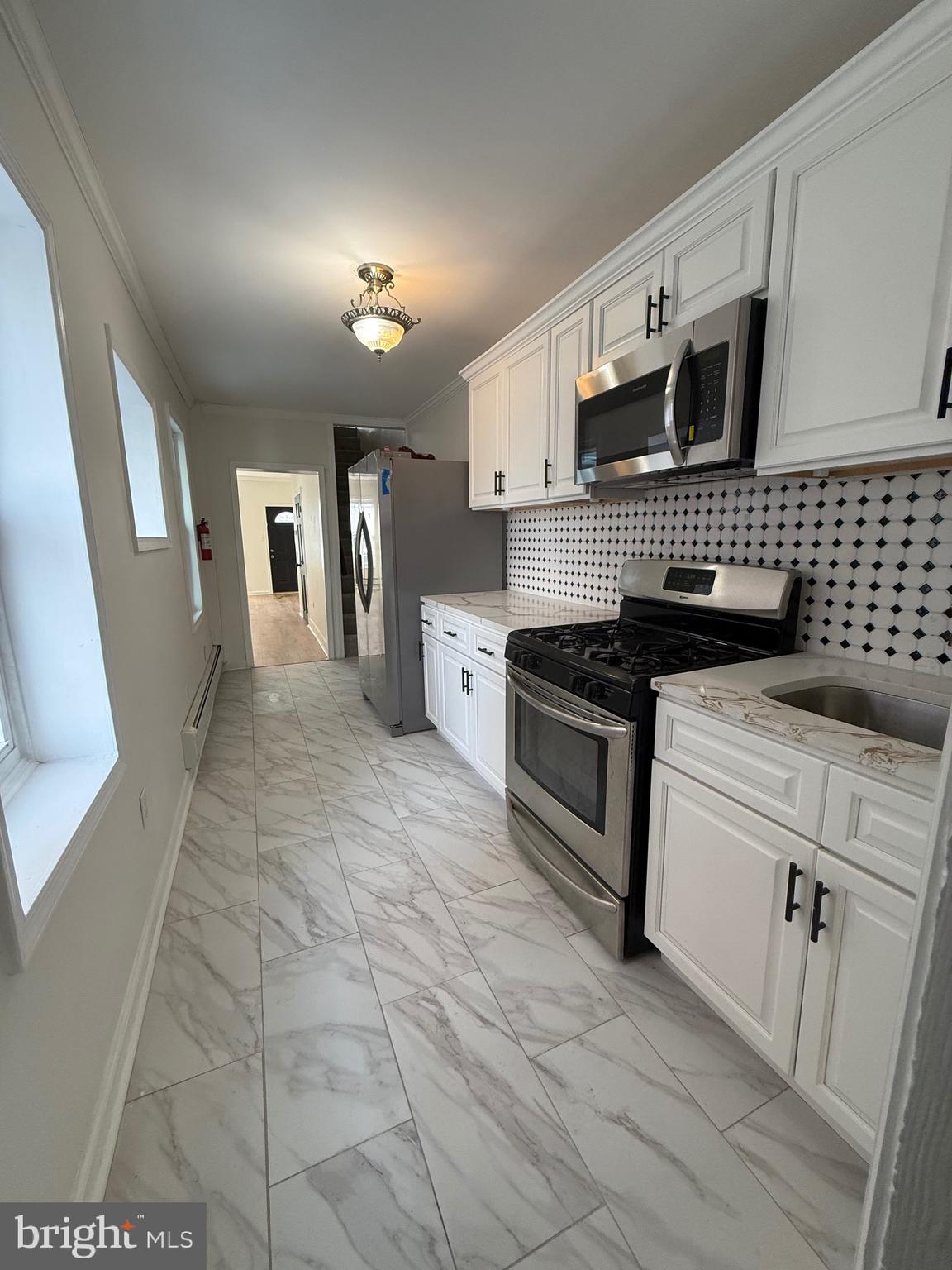 542 Moss Street Reading, PA 19604 - Photo 7 of 19 a kitchen with stainless steel appliances granite countertop a stove a sink and a refrigerator