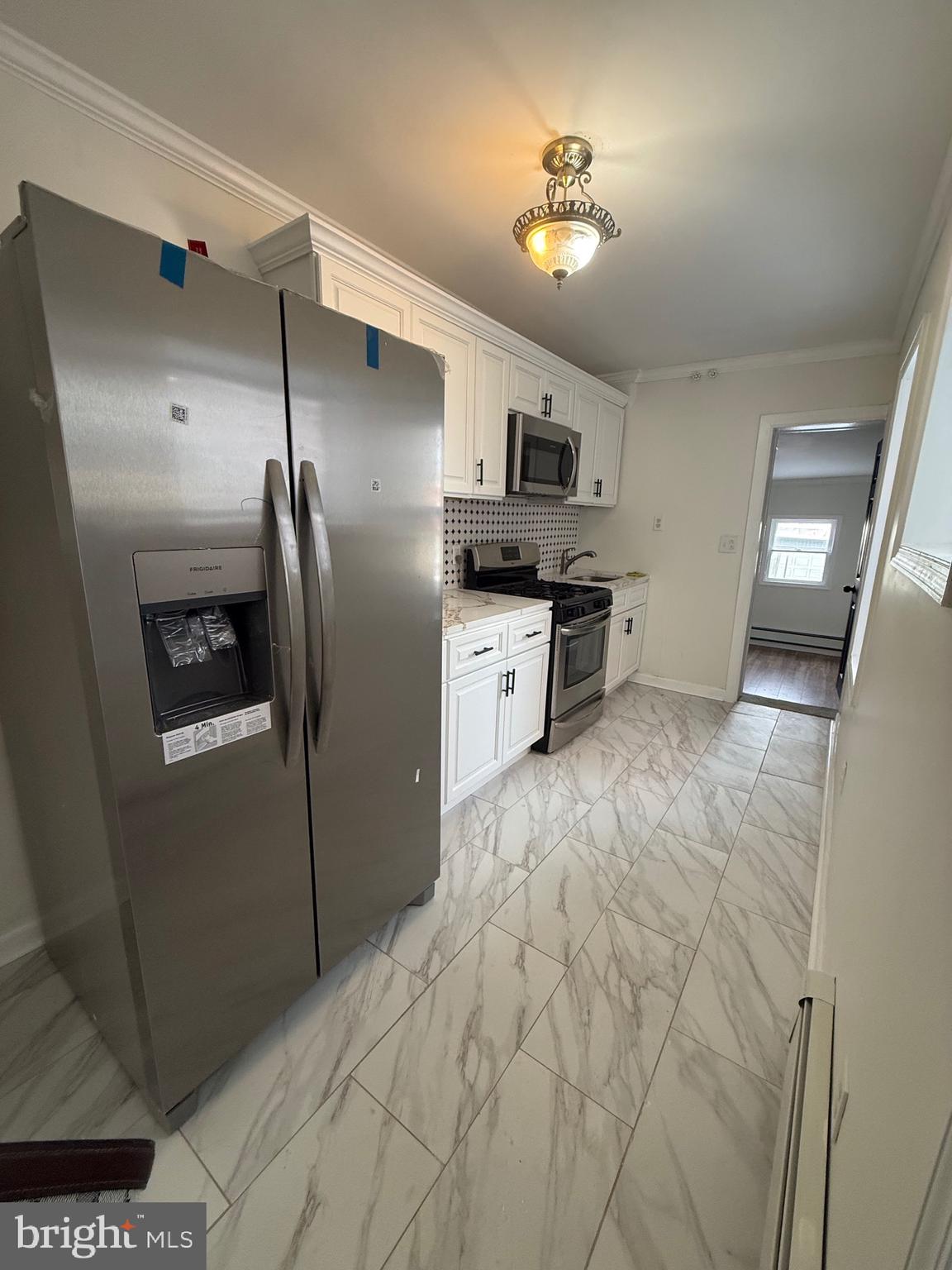542 Moss Street Reading, PA 19604 - Photo 8 of 19 a kitchen with stainless steel appliances a refrigerator sink and microwave