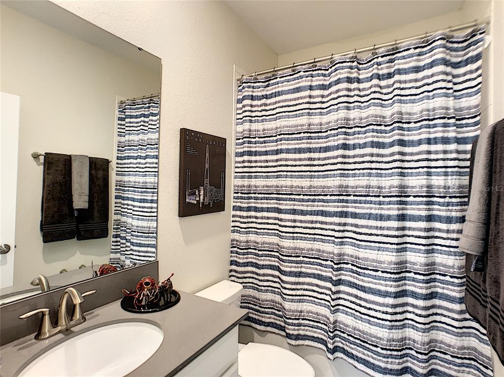 2736 Bookmark Drive Kissimmee, FL 34746 - Photo 17 of 35 a bathroom with a sink a mirror and shower