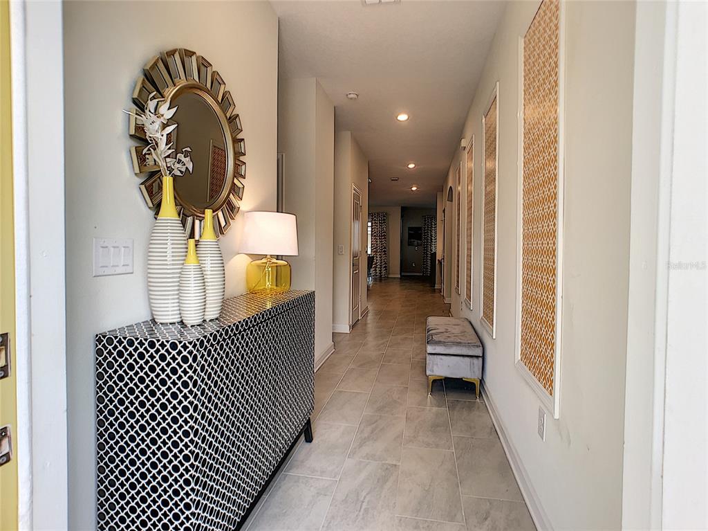 2736 Bookmark Drive Kissimmee, FL 34746 - Photo 2 of 35 a hallway with a large mirror and a potted plant