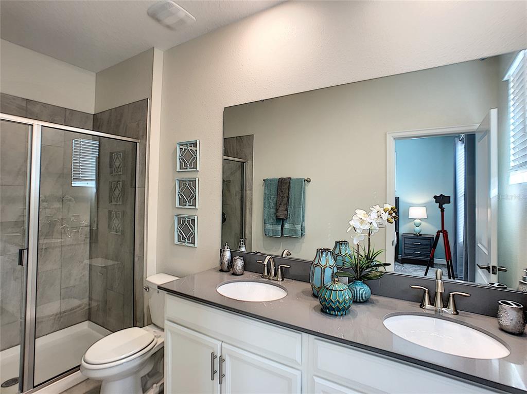 2736 Bookmark Drive Kissimmee, FL 34746 - Photo 23 of 35 a bathroom with a double vanity sink toilet and shower