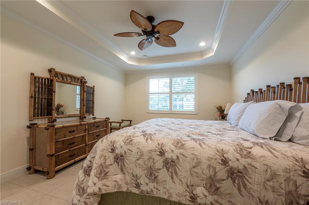 6954 Avalon Circle, Unit 702 Naples, FL 34112 - Photo 12 of 40 a bedroom with a bed and a flat screen tv