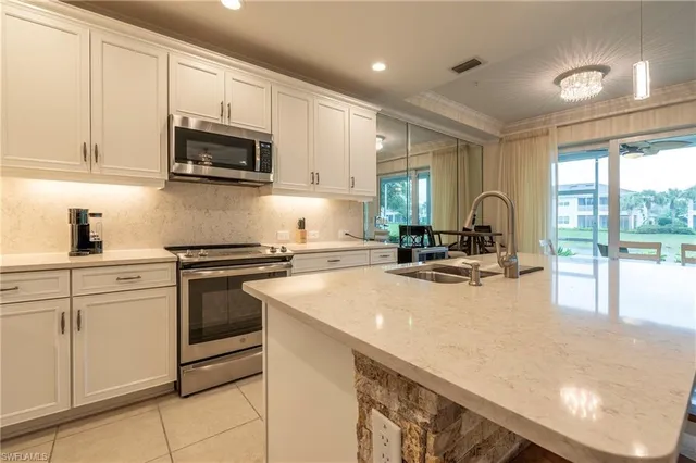a kitchen with sink a microwave and cabinets