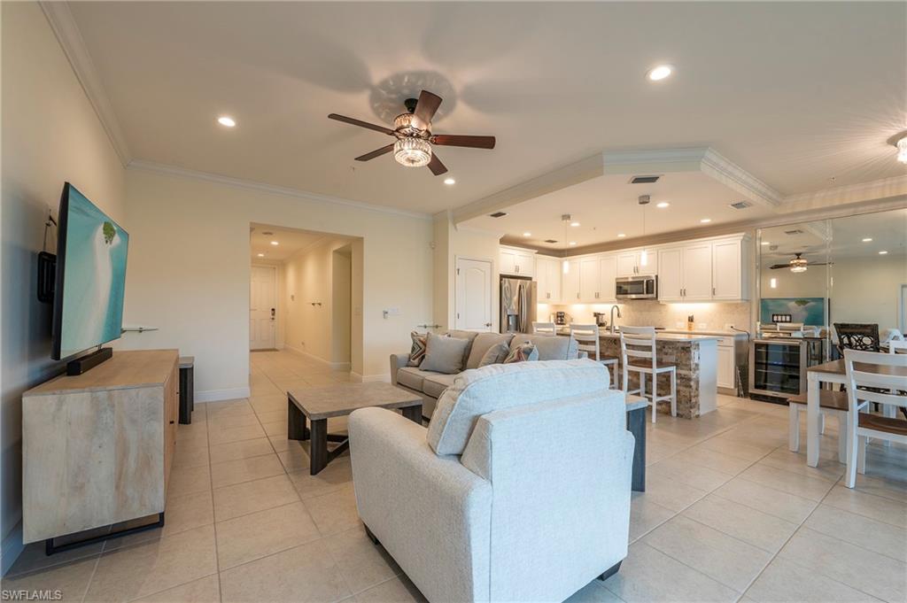 6954 Avalon Circle, Unit 702 Naples, FL 34112 - Photo 19 of 40 a living room with furniture and a flat screen tv