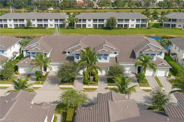 an aerial view of a house with a yard and lake view